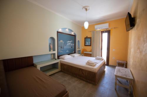 a bedroom with two beds and a tv in it at Orfeas Apartments in Kamari