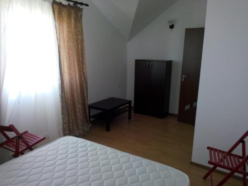 a bedroom with a bed and two chairs and a window at Vila Antonia in Eforie Nord