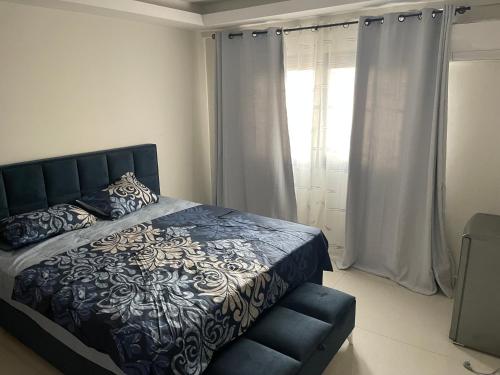 a bedroom with a black and white bed and a window at Studio meublé Centre-ville Dakar in Dakar