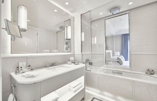a white bathroom with a sink and a mirror at Hôtel Martinez, in The Unbound Collection by Hyatt in Cannes