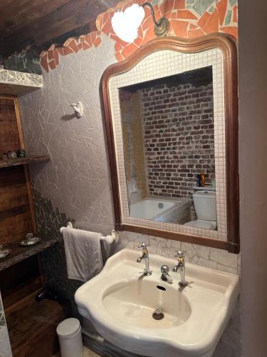 a bathroom with a sink and a mirror at Le Temps d'un Rêve in Ravenel