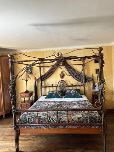 uma cama com uma moldura de metal ornamentada num quarto em Le Temps d'un Rêve em Ravenel