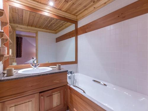 une salle de bain avec une baignoire blanche et un lavabo dans l'établissement Appartement élégant aux pieds des pistes avec cheminée et WiFi - FR-1-694-213, à Val dʼIsère