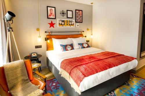 a bedroom with a large bed and a chair at Hotel Indigo Belgrade by IHG in Belgrade