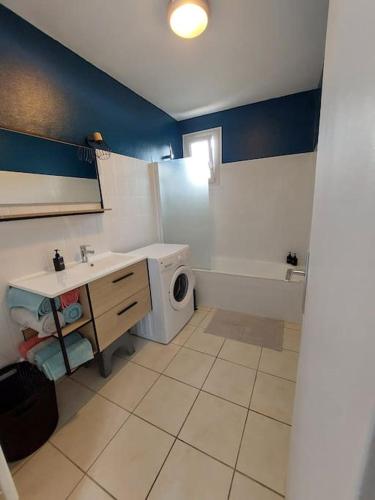 uma casa de banho com um lavatório e uma máquina de lavar roupa em 2 pièces à deux pas de la plage. em Fouesnant