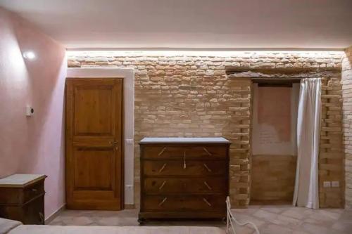 sypialnia z ceglaną ścianą i drewnianymi drzwiami w obiekcie Casolare della Quiete w mieście Corridonia