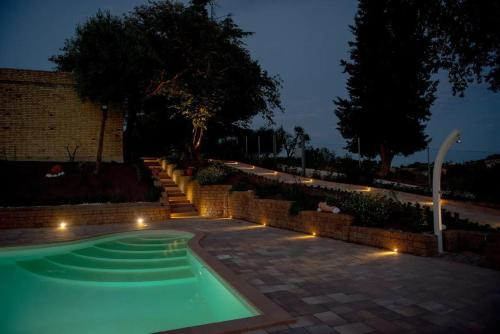 basen z oświetleniem w ogrodzie w nocy w obiekcie Casolare della Quiete w mieście Corridonia