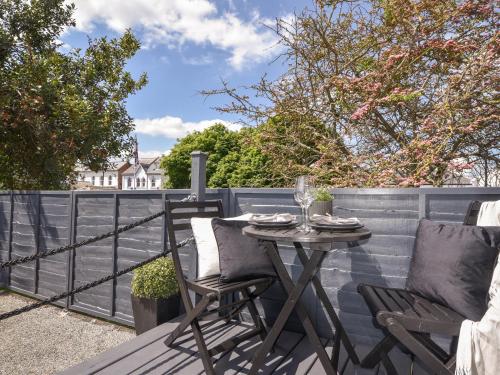 a table and chairs on a patio with a fence at Fore Street House - Apartment 2 in Seaton