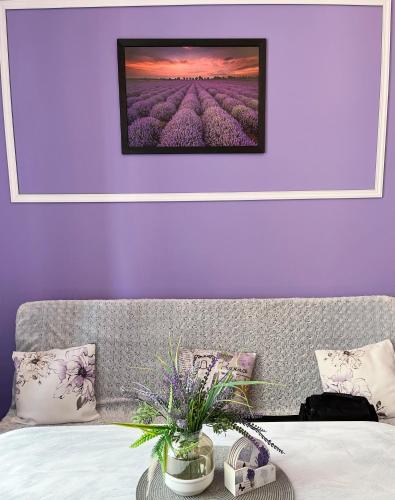 a bedroom with purple walls and a bed with flowers at Apartament Lawendowy in Wałbrzych