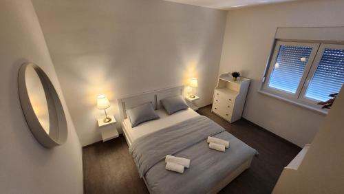 1 dormitorio con 1 cama, 2 lámparas y espejo en Hidden Sunset en Selca