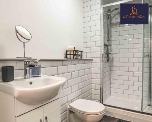a bathroom with a sink and a toilet and a mirror at Swan House Apartment 2 - 1 Bed Apartment - Sleeps up to 4 - Free Parking - Liverpool - close to city centre - By ALL ELITE STAYS in Liverpool