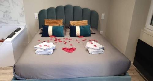 a bedroom with a bed with towels and flowers on it at Superbe appartement avec Balnéothérapie/spa/ Champagne in Pornic