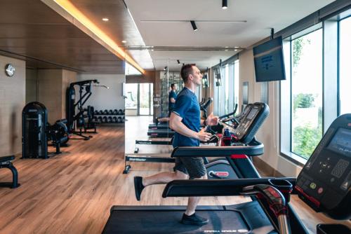 a man on a treadmill in a gym at Holiday Inn & Suites - Dubai Science Park by IHG in Dubai