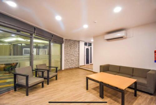 a living room with a couch and a table and chairs at FabExpress Heera Holiday Inn - Nr Eden Garden Stadium in Kolkata