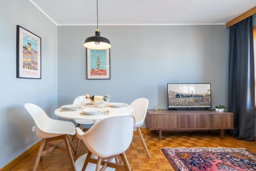 a dining room with a table and chairs and a tv at Host Wise - Fantastic Peaceful Flat in Gaia in Vila Nova de Gaia