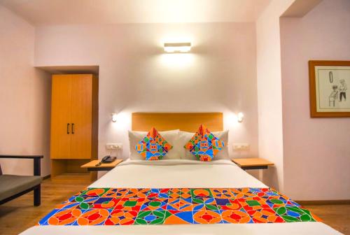 a bedroom with a large bed with a colorful quilt at FabHotel Heera Holiday Inn in Kolkata