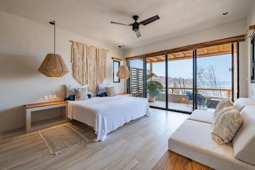 Un dormitorio con una cama blanca y un sofá. en 2049 - Amanecer A1, en Santa Cruz Huatulco