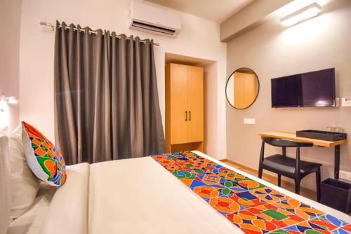 a bedroom with a bed and a desk in a room at FabHotel Heera Holiday Inn in Kolkata