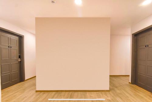 an empty room with two doors and wood floors at FabExpress Heera Holiday Inn - Nr Eden Garden Stadium in Kolkata