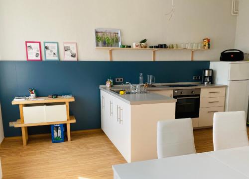 uma cozinha com armários brancos e uma parede azul em Studio mit Küche em Pirna