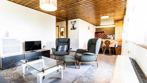 a living room with chairs and a table and a tv at Ferienwohnung Chalet Bortelhorn, Rosswald in Termen