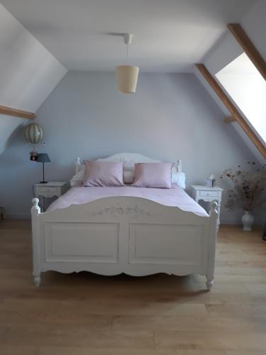a bedroom with a white bed with pink pillows at Thérouanne en Berry in Plaimpied-Givaudins