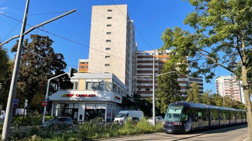 un bus circulant dans une rue à côté d'un bâtiment dans l'établissement Happy Studio terrace, à Schiltigheim