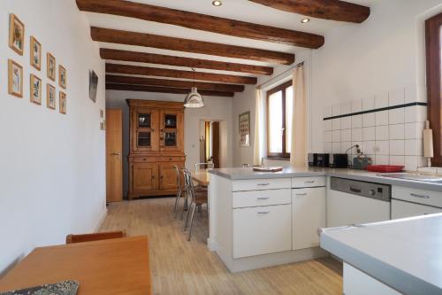 une grande cuisine avec des armoires blanches et une table dans l'établissement L'Hortensia blanc, à Bergholtz