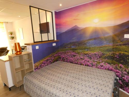 - une chambre avec un lit et une fresque murale fleurie dans l'établissement Charmant studio lumineux avec Wifi, à La Bourboule