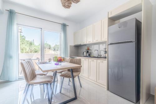 a kitchen with a table and a refrigerator at Elegant Suite 4 Near the Beach in Ayía Marína