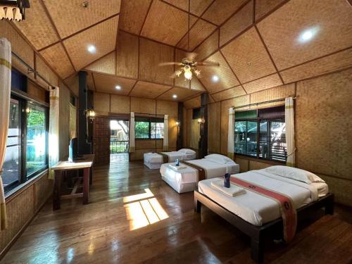 Habitación con 3 camas y techo. en Dreamer Club Resort Treehouse Suspension Bridge Pool, en Chiang Mai
