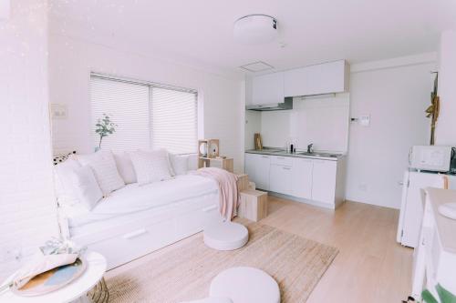 a white living room with a white couch and a kitchen at moof Osaka trendy spot Spacious Apt in Osaka