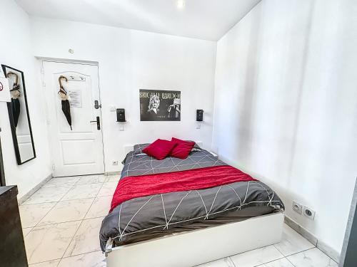a white bedroom with a bed with red pillows at Sweet Home Marceau 6 studios hyper centre proche de la mer et du palais in Cannes