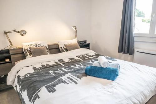 um quarto com uma cama com um edredão preto e branco em COSYFAMILY 2-6pers-PISCINE-Jardin- Barbecue- CoHôte Conciergerie Pérols em Pérols