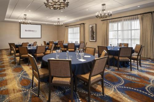 a conference room with tables and chairs and a projection screen at Residence Inn by Marriott Santa Barbara Goleta in Santa Barbara