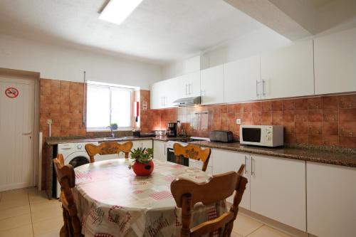 a kitchen with a table and a kitchen with white cabinets at Cantinho da Ana in Tomar