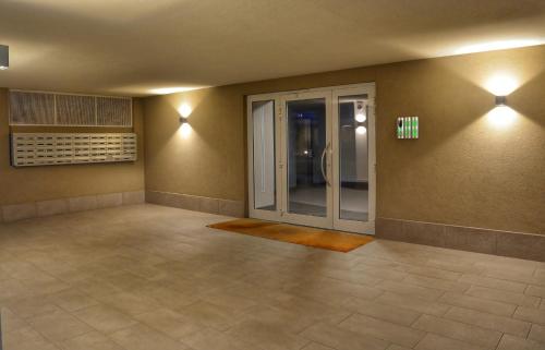 une pièce vide avec une porte en verre dans un bâtiment dans l'établissement Bloom Apartment, à Pero