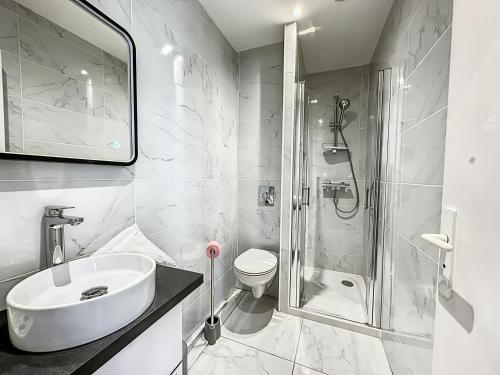 une salle de bain blanche avec un lavabo et une douche dans l'établissement Sweet Home Marceau 6 studios hyper centre proche de la mer et du palais, à Cannes