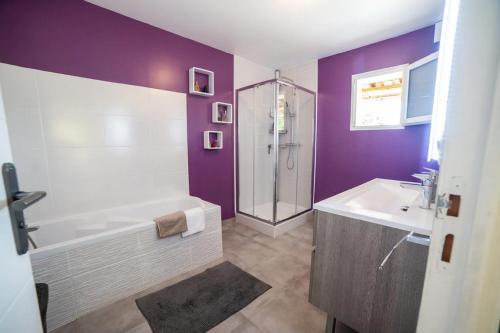 une salle de bain avec une baignoire blanche et un lavabo dans l'établissement COSYFAMILY RDC 6pers-PISCINE-Jacuzzi-Jardin- Barbecue- TopPros Conciergerie Pérols, à Pérols