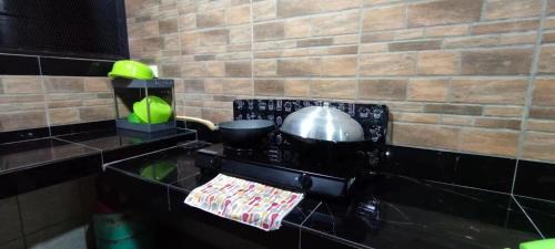 uma cozinha com fogão com panela e frigideiras em S99 HOMESTAY KUDAT em Kudat
