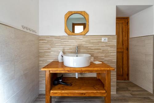 La salle de bains est pourvue d'un lavabo et d'un miroir. dans l'établissement Casa Sonia, à Osilo