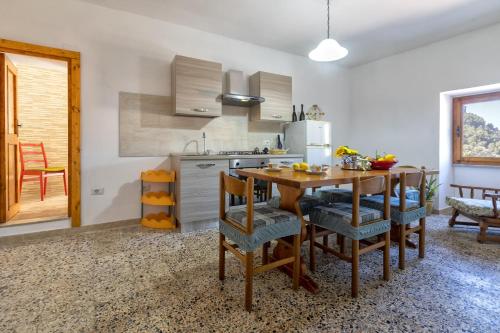 a kitchen with a wooden table and some chairs at Casa Sonia in Osilo