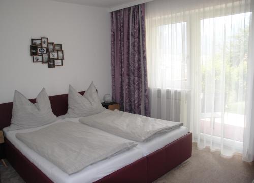 a bedroom with a bed with white sheets and a window at Haus Wohleb in Fulpmes