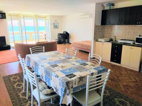 a kitchen and dining room with a table and chairs at Apartments Grkinić in Karlobag