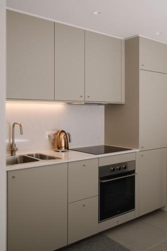 a kitchen with white cabinets and a sink and a stove at Aldoar House in Porto