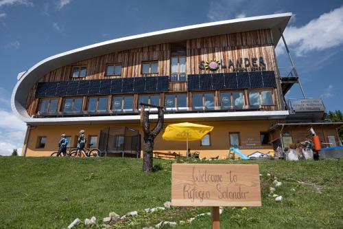 a building with a sign in front of it at Hotel Rifugio Solander in Commezzadura