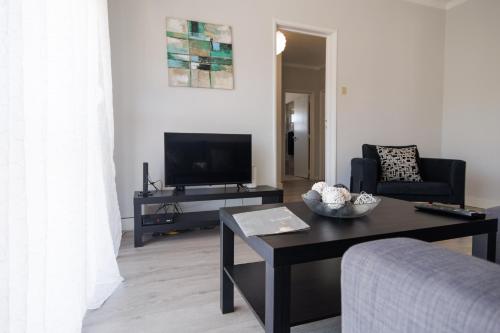 a living room with a tv and a table at Cantinho da Ana in Tomar