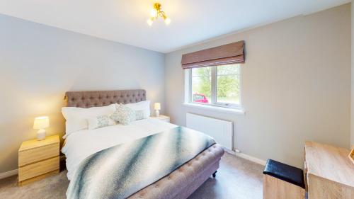a bedroom with a bed and a window at Braeside - Family home in Nethy Bridge in Nethy Bridge