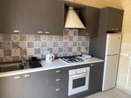 a kitchen with a sink and a stove top oven at 2 Bedroom Apartment in Qala - Gozo in Qala