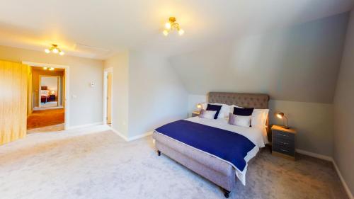 a bedroom with a bed with blue sheets and pillows at Braeside - Family home in Nethy Bridge in Nethy Bridge